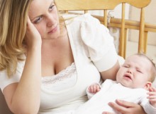 Worried Mother Holding Baby In Nursery