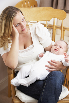 Worried Mother Holding Baby In Nursery