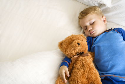 Child sleeping with bear.