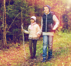 two happy kids walking along forest path