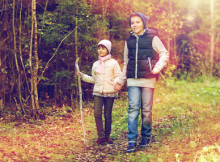 two happy kids walking along forest path